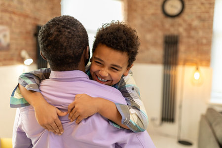 Dad and son hugging and looking happy and enjoyedの写真素材