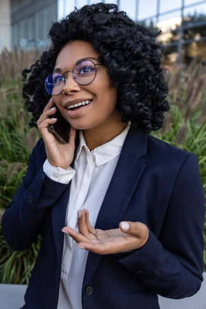 Good-looking business woman in a nice suit with a phone in handsの写真素材