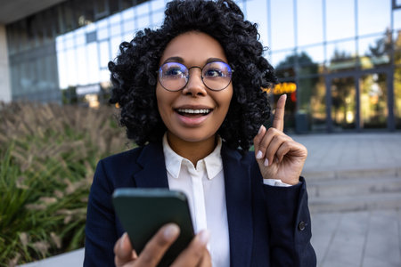 Business woman standing with a phone in hands and looking thoughtfulの写真素材