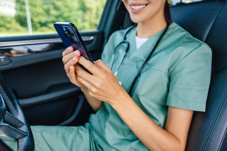 Female doctor in lab suit with a phone in hand texting to a patient