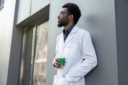 African american male doctor having a coffee break and looking relaxedの写真素材