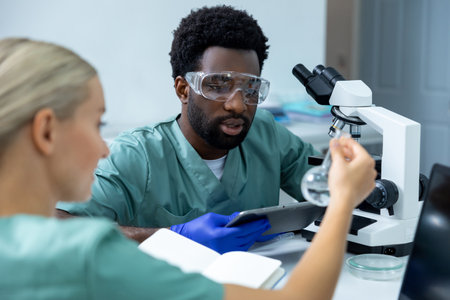 Male and female microbiologists working team in scientific lab conducting experimentsの写真素材
