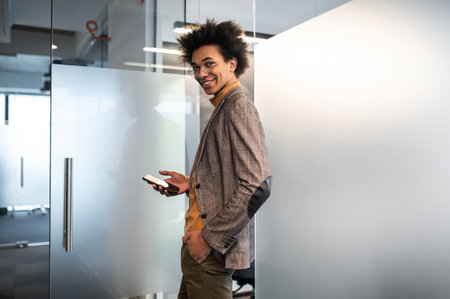 Confident curly-haired young businessman in the office