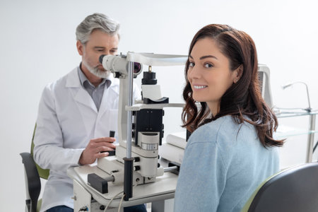 Male doctor examining woman patient vision with professional equipment for diagnosisの写真素材