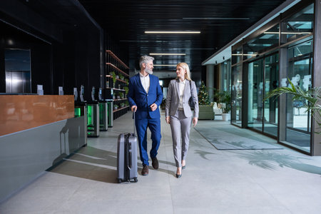 Business owner meeting a partner in the airport and going to the exitの写真素材
