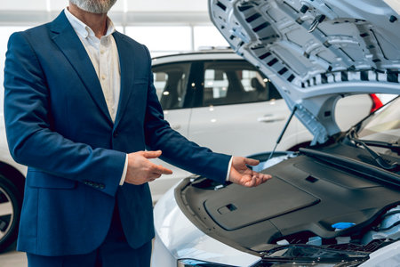 Man in car service center or workshop with new car with open hoodの写真素材