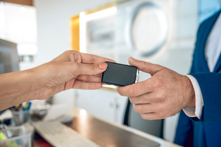 Hand of car dealer giving new car key to customer.の写真素材