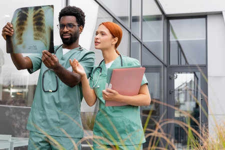 Two doctors woman and man examining X-ray scan in clinicの写真素材