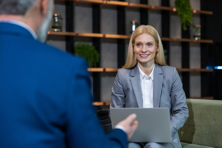 Blonde business woman having an interview with a work candidate and looking involvedの写真素材