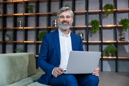 Gray-haired mature business man in elegant suit in his working placeの写真素材