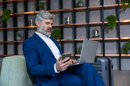 Gray-haired mature business man in elegant suit in his working placeの写真素材