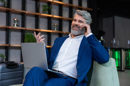 Gray-haired mature business man in elegant suit in his working placeの写真素材