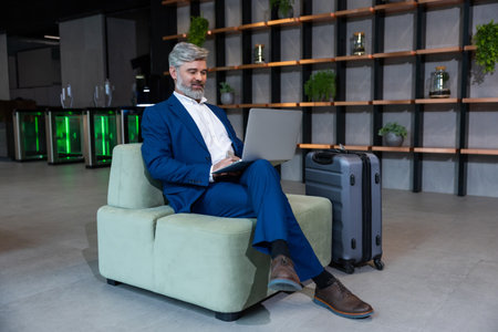 Well-dressed elegant business man working on laptop in his officeの写真素材