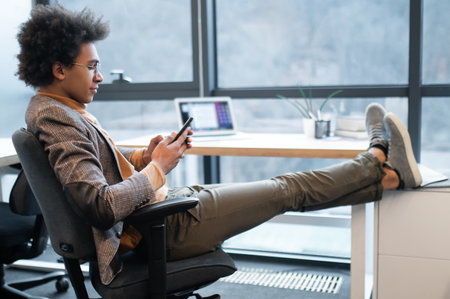 Young man using smartphone in officeの写真素材