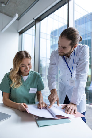 Doctors working on PC analyzing research data talking with colleaguesの写真素材