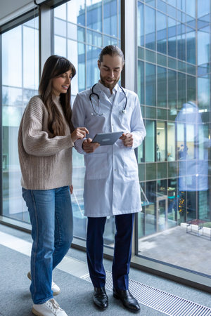 Physician using tablet to discuss health care plan with patientの写真素材