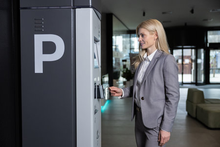 Woman inserting card into machine for parking ticket payment with wireless systemの写真素材