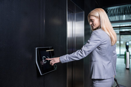 Blonde woman in elegant suit waiting for the elevatorの写真素材