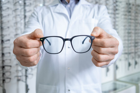 Close up picture of male ophthalmologist with glasses in hands