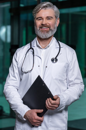Mature male doctor in lab coat entering the clinic and looking determinedの写真素材