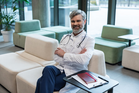 Smiling mature male doctor in lab coat looking positive and contentedの写真素材