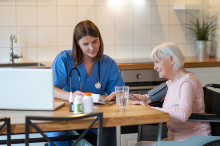 Female doctor helping senior patient with blood pressure test and pulse measurementの写真素材