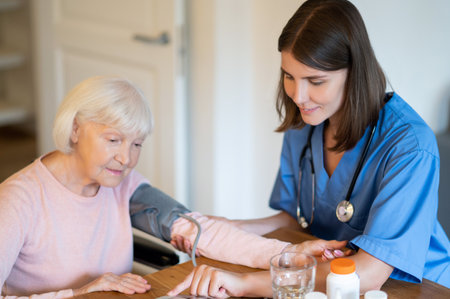 Medical professional helping elderly patient with blood pressure and pulse monitoringの写真素材