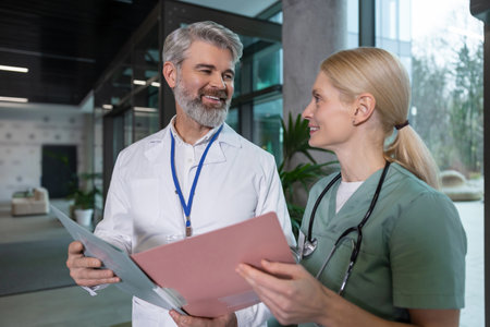 Female and male doctors discussing patients medical case and looking excitedの写真素材