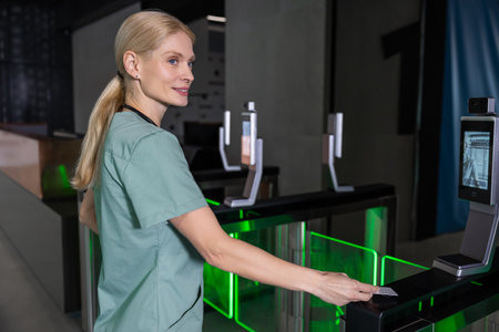 Female doctor in lab coat passing through security control by using access cardの写真素材