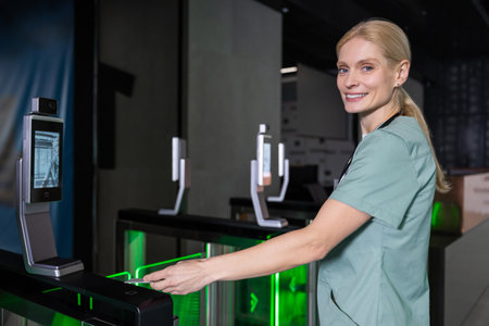 Female doctor in lab coat passing through security control by using access cardの写真素材