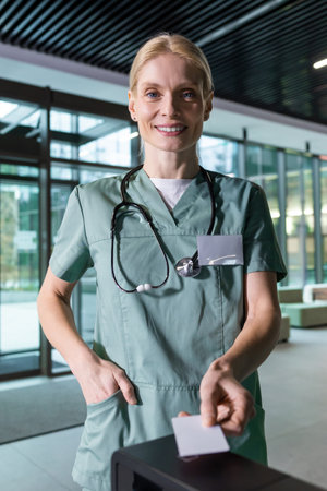 Female blonde doctor passing through security by using access cardの写真素材