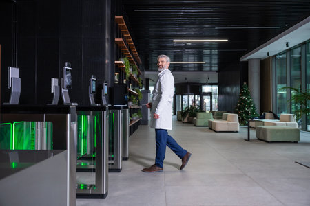 Male doctor going to the security entrance while coming to his working placeの写真素材