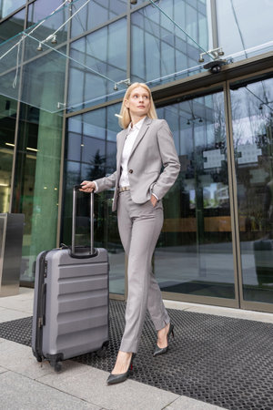 Professional woman traveling with luggage ready for business tripの写真素材