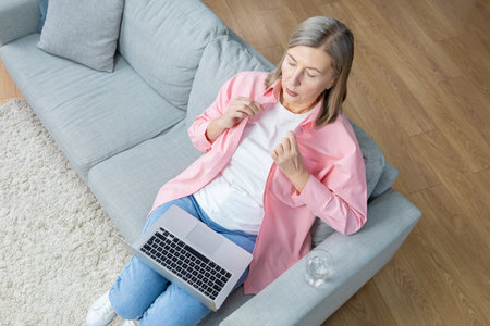 Top view of a woman sitting on the sofa with a laptopの写真素材