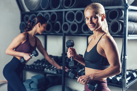 Fit and sporty young caucasian women with dumbbells in the gymの写真素材