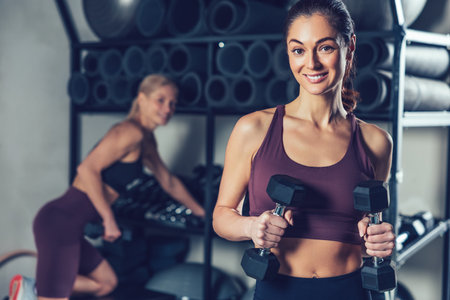 Cute young dark-haired woman looking contented spending time in the gymの写真素材