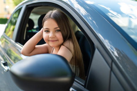 Female kid sitting in car excited for vacation road trip on holidayの写真素材