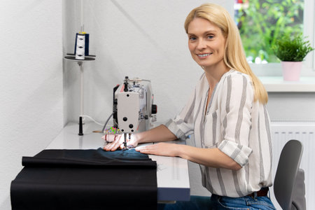 Pretty young female fashion designer working in her studioの写真素材