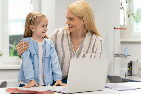 Pretty young caucasian woman in her design studio with her daughterの写真素材