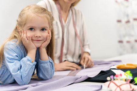 Cute blonde child cutting out a new model in a design studioの写真素材