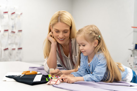 Cute blonde child cutting out a new model in a design studioの写真素材