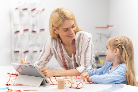 Mom and daughter spending time together in the design studio and looking contentedの写真素材