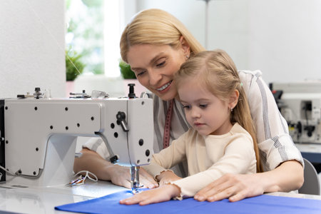 Mom and kid in a dress design studio working together on a new collectionの写真素材