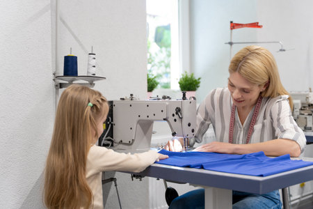 Cute little girl spending time with her mom in a designers studioの写真素材