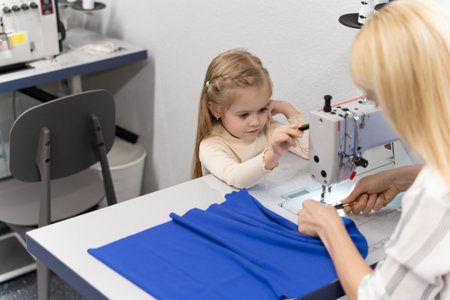 Cute little girl spending time with her mom in a designers studioの写真素材