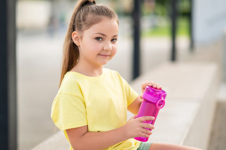 Kid drinking water from bottle enjoying active lifestyleの写真素材