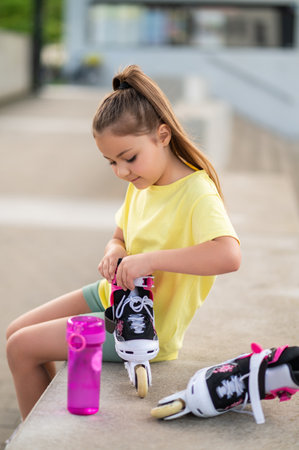 Little girl with roller-skates playing outsideの写真素材