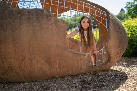 Female child smiling playing on outdoor playground in daytimeの写真素材