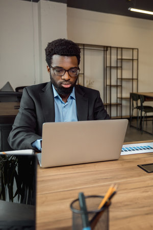 African american businessman working on laptop and looking serious and focusedの写真素材