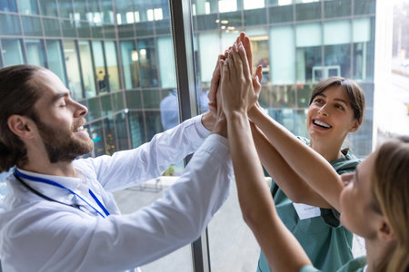 Group of doctors holding hands together and looking positive and smilingの写真素材